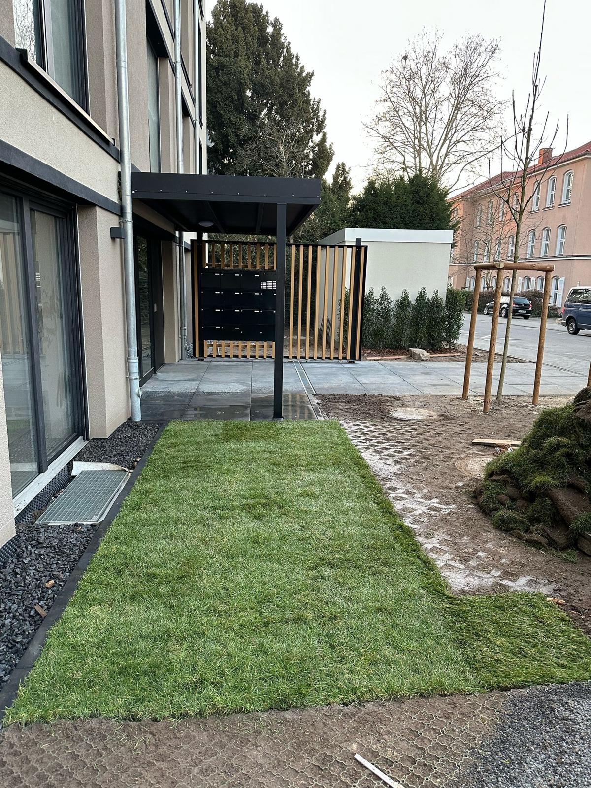 Gepflegte Rasenfläche mit angrenzendem Beet und Wegführung